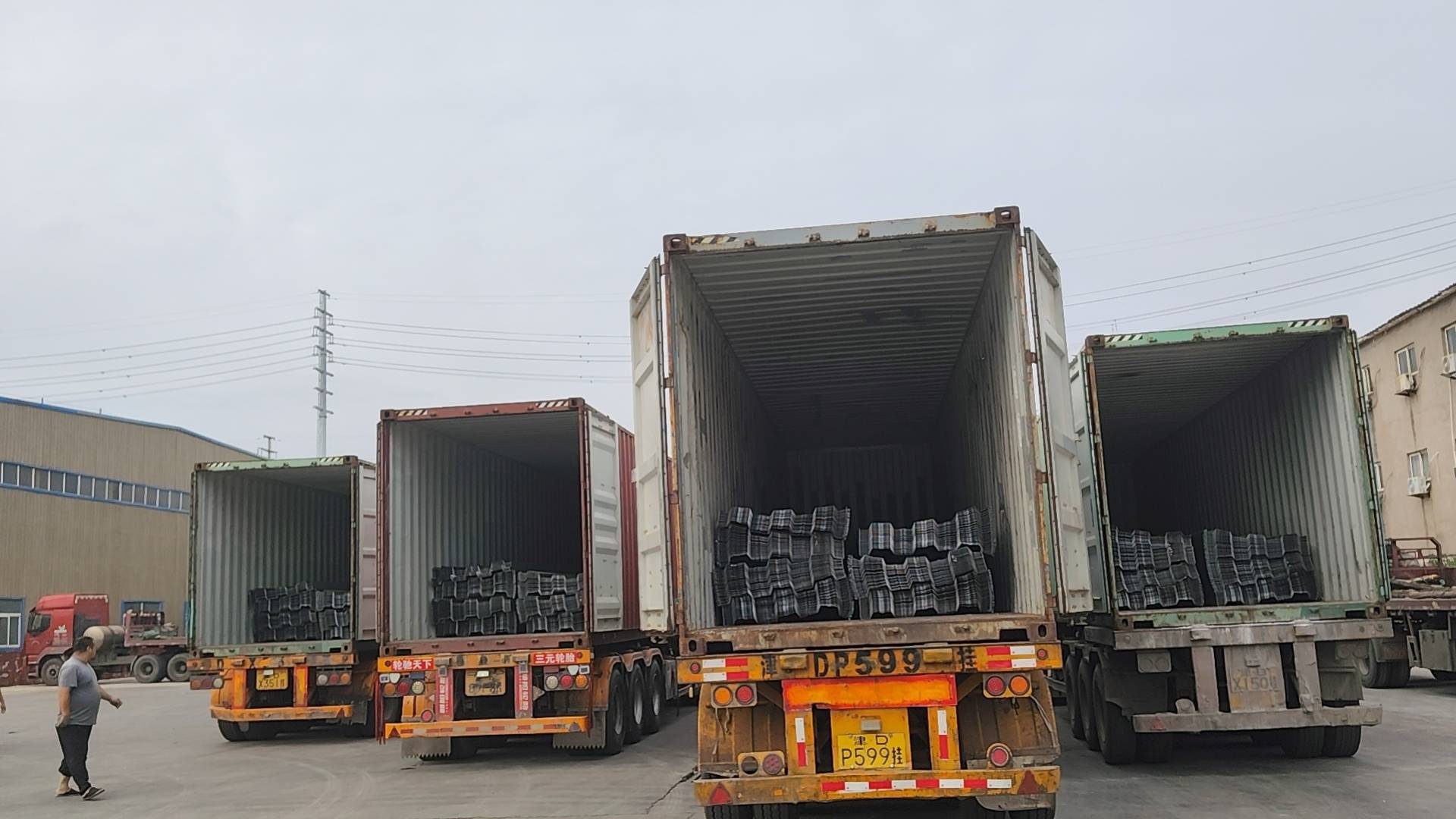 Four open containers holding metal decking at the factory loading site